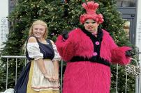 Cinderella and the Dame standing in front of a Christmas tree